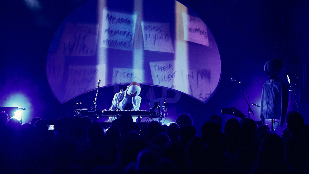 Le concert sous un éclairage violet et des projections